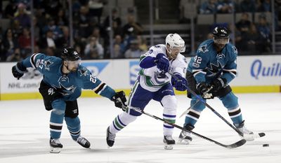 Vancouver Canucks&#39; Henrik Sedin, center, is defended by San Jose Sharks&#39; Joonas Donskoi (27) and Joel Ward (42) during the first period of an NHL hockey game Tuesday, April 4, 2017, in San Jose, Calif. (AP Photo/Marcio Jose Sanchez)
