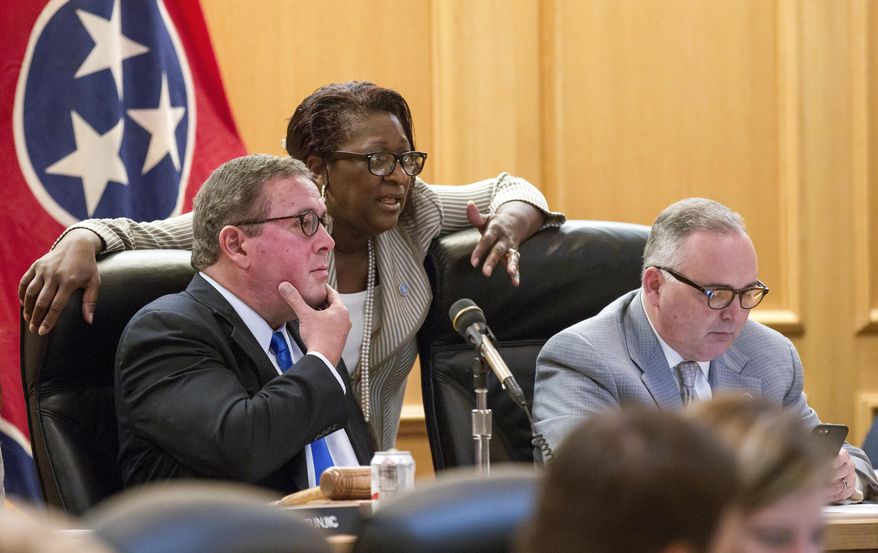 Rep. Gerald McCormick, R-Chattanooga, left, confers with Rep. Karen Camper, D-Memphis, before a House Finance Subcommittee in Nashville, Tenn., on Wednesday, April 5, 2017. Rep. Kevin Brooks, R-Cleveland is at right. The panel later voted to advance Republican Gov. Bill Haslam's road funding proposal that would include the state's first gas tax hike since 1989. (AP Photo/Erik Schelzig)