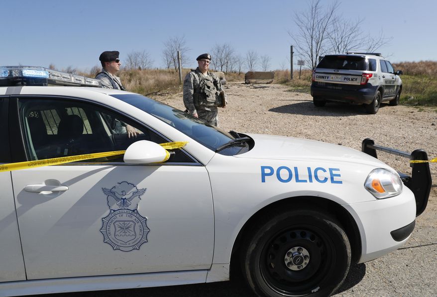 Air Force Security officers secure the area near the location where a military aircraft crashed, Wednesday, April 5, 2017, in Clinton, Md. The Air Force said that the pilot was on a training mission in an F-16 from the Andrews Air Force-based 113th Wing. Officials say the pilot ejected and is safe. The plane went down a few miles from Andrews. (AP Photo/Pablo Martinez Monsivais)