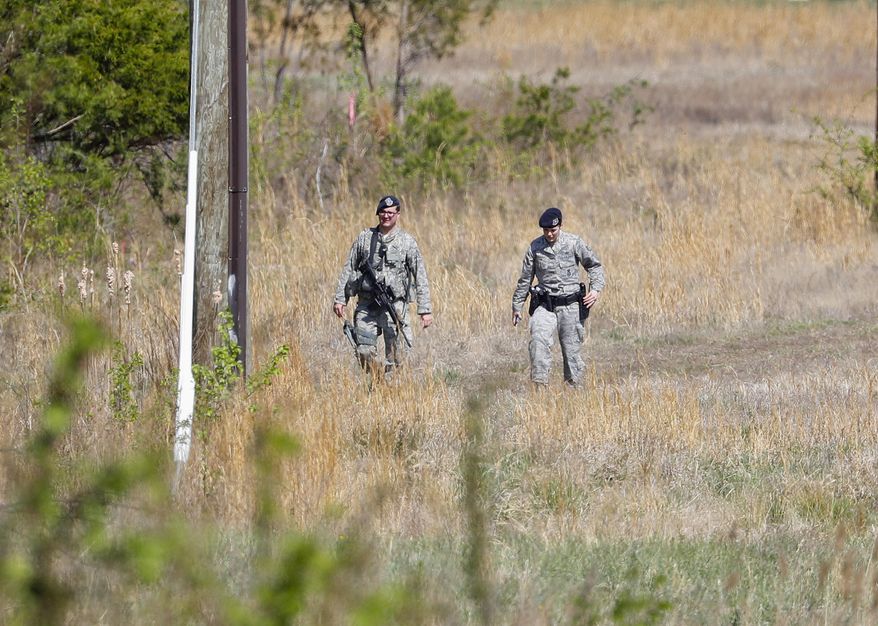 Air Force Security officers patrol the area near the location where a military aircraft crashed, Wednesday, April 5, 2017, in Clinton, Md. The Air Force said that the pilot was on a training mission in an F-16 from the Andrews Air Force-based 113th Wing. Officials say the pilot ejected and is safe. The plane went down a few miles from Andrews. (AP Photo/Pablo Martinez Monsivais)