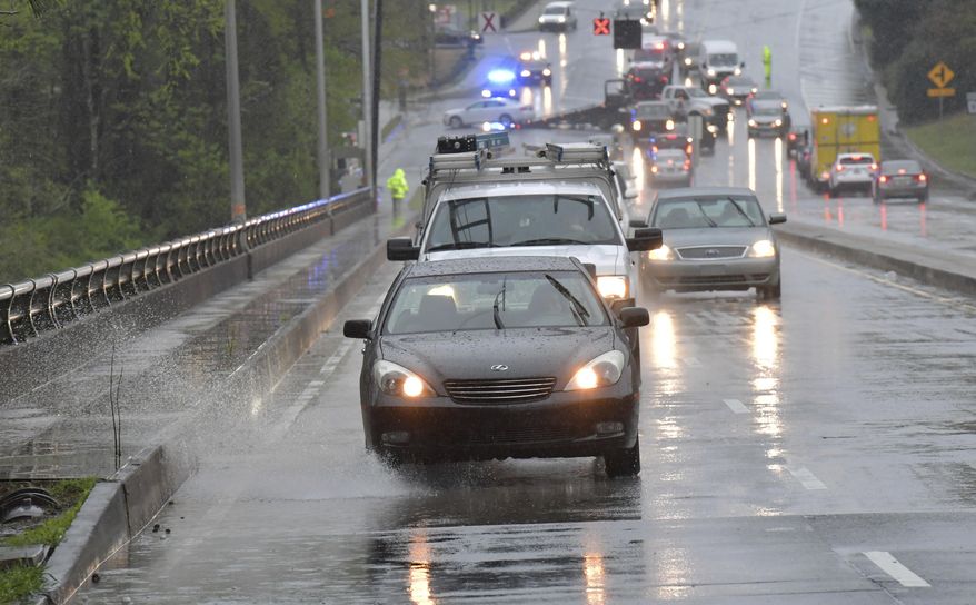 Motorists drive during heavy rain in Roswell, Ga., on Wednesday, April 5, 2017. Severe weather toppled trees and power lines as dangerous storms battered the Deep South with heavy rain and hail as large as baseballs in spots. (Hyosub Shin/Atlanta Journal-Constitution via AP)