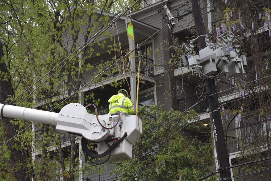 Georgia Power crews work to restore power lines along Azalea Drive in Roswell, Ga., on Wednesday, April 5, 2017. Severe weather toppled trees and power lines as dangerous storms battered the Deep South with heavy rain and hail as large as baseballs in spots. (Hyosub Shin/Atlanta Journal-Constitution via AP)