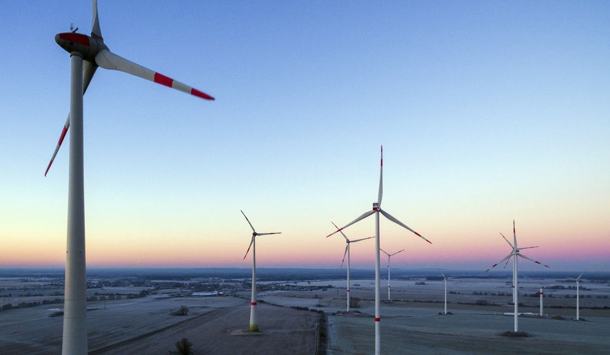 The sun is rising in the morning sky above a landscape with a wind energy park near Jacobsdorf, Germany, in this Dec. 31, 2016, file photo. U.N.-backed report says global investments in renewable energy fell by almost a quarter last year amid a drop in prices and lower spending in some markets. The United Nations Environment Program said Thursday, April 6, 2017, that overall investments reached $241.6 billion last year, down from $312.2 billion in 2015.  (Patrick Pleul/dpa via AP,file)