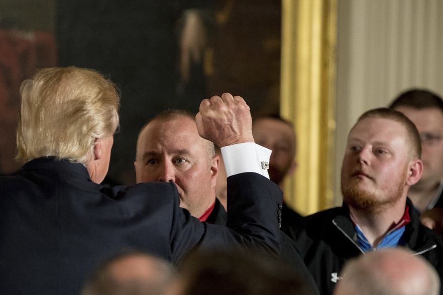 President Donald Trump raises a fist as he greets servicemen at a Wounded Warrior Project Soldier Ride event in the East Room of the White House in Washington, Thursday, April 6, 2017. (AP Photo/Andrew Harnik)