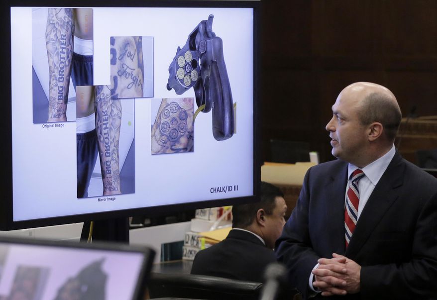 Assistant district attorney Patrick Haggan makes closing arguments as images showing tattoos belonging to former New England Patriots tight end Aaron Hernandez are displayed on a screen during Hernandez's double murder trial at Suffolk Superior Court, Thursday, April 6, 2017, in Boston. Hernandez is on trial for the July 2012 killings of Daniel de Abreu and Safiro Furtado who he encountered in a Boston nightclub. The former NFL player is already serving a life sentence in the 2013 killing of semi-professional football player Odin Lloyd. (AP Photo/Steven Senne, Pool)