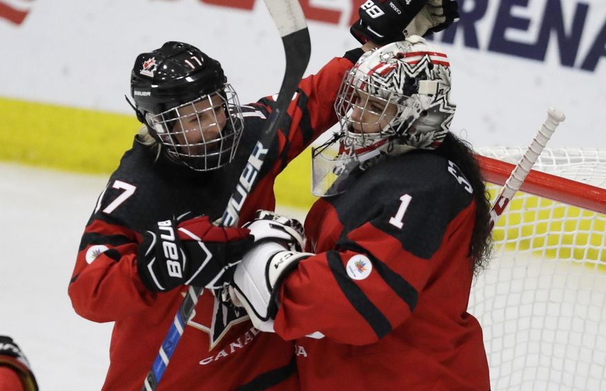 Canada forward Bailey Bram (17) pats goalie Shannon Szabados after the third period of an IIHF women&#x27;s world hockey championship semifinal game against Finland on Thursday, April 6, 2017, in Plymouth, Mich. (AP Photo/Carlos Osorio)