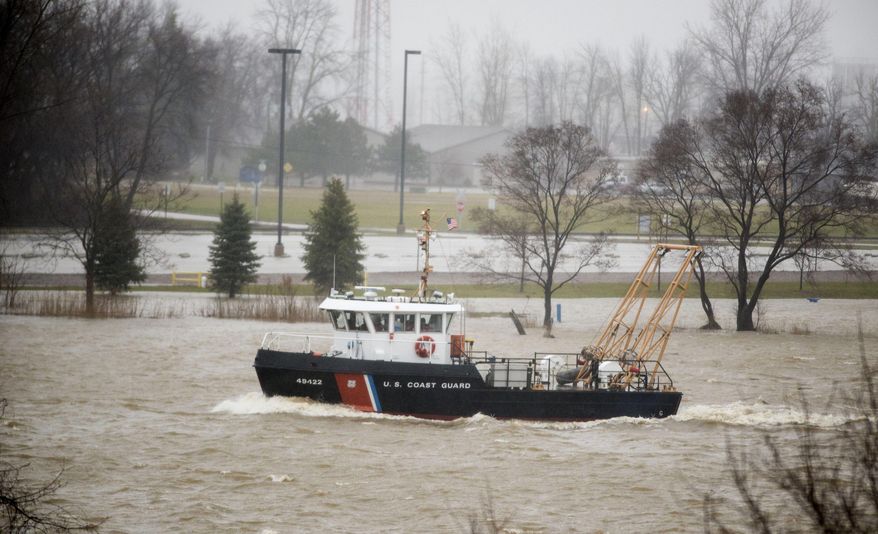 A U.S. Coast Guard tug sails down the Saginaw River near Independence Bridge, in Bay County, Mich., on Thursday, April 6, 2017. A mix of snow and rain across much of Michigan is causing hazardous driving conditions and bringing the threat of flooding in places. (Jacob Hamilton /The Bay City Times via AP)