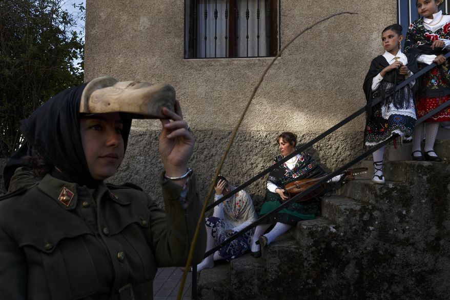 In this April 1, 2017 picture revelers from San Pedro Bernardo village wearing the traditional 'Machurrero' mask and outfit rest after a parade during a gathering of different villages' carnival masks and characters in the small village of Casavieja, Spain, Monday, April 3, 2017. (AP Photo/Daniel Ochoa de Olza)