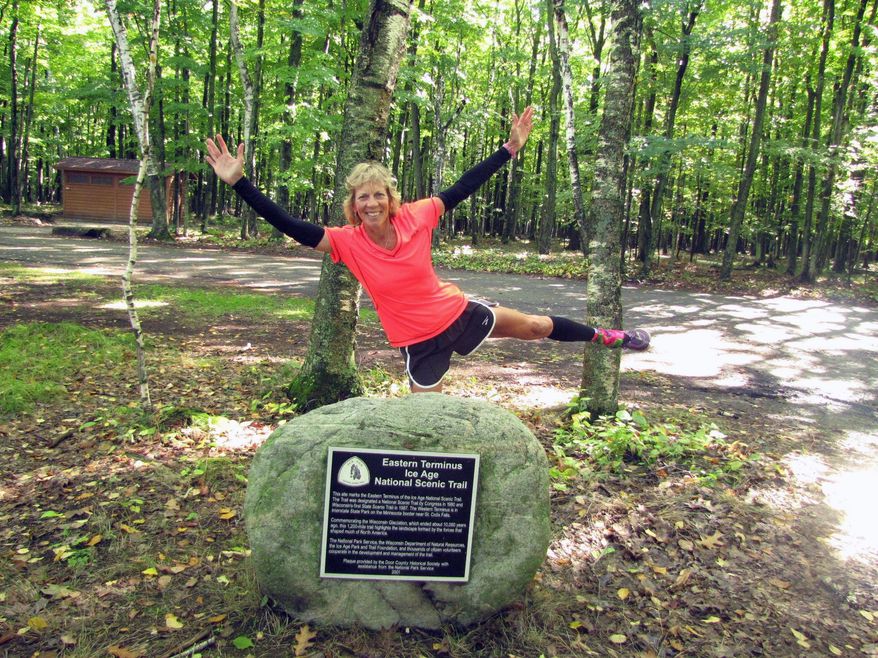 This Oct. 6, 2013 photo shows Melanie McManus at the eastern terminus of the Ice Age Trail in Potawatomi State Park in Sturgeon Bay, Wis. McManus wrote a book, "Thousand-Miler: Adventures Hiking the Ice Age Trail," about the experiences she and others have had hiking the trail. McManus completed the trail in 36 days in 2013 and 34 days in 2015. (Ed McManus via AP)