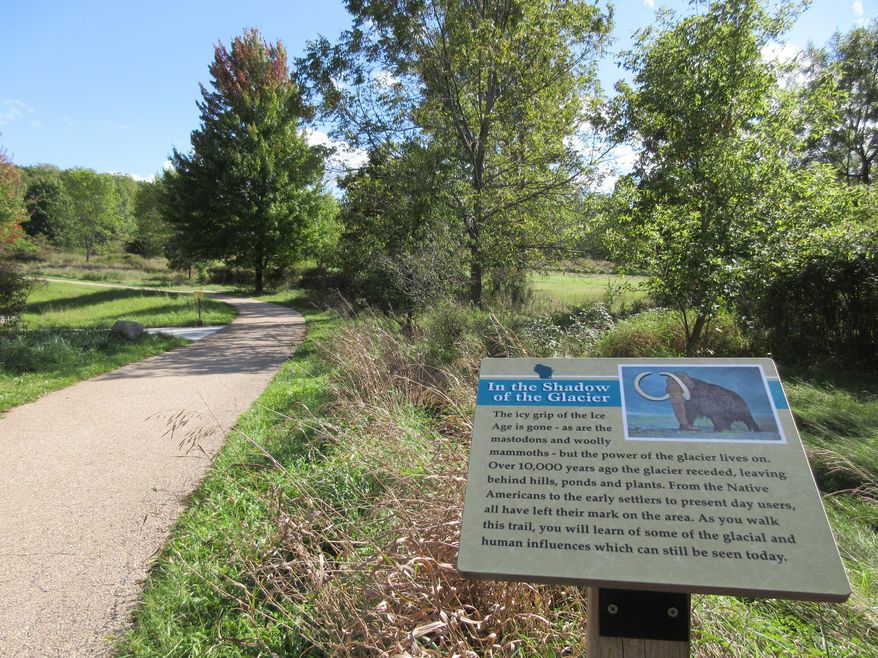This Sept. 26, 2016 photo shows a sign in a park in Delafield, Wis., describing how retreating glaciers sculpted the landscape. A new book, "Thousand-Miler: Adventures Hiking the Ice Age Trail," by Melanie McManus, documents the experiences she and others have had hiking Wisconsin's 1,100-mile Ice Age Trail. (AP Photo/Beth J. Harpaz)