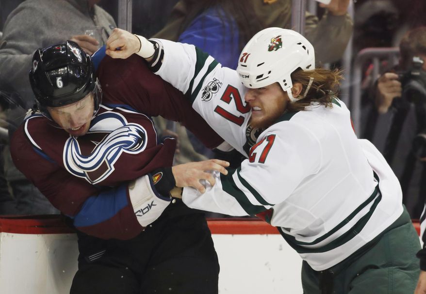 Minnesota Wild center Ryan White, right, throws a punch at Colorado Avalanche defenseman Erik Johnson as the pair fight in the second period of an NHL hockey game Thursday, April 6, 2017, in Denver. (AP Photo/David Zalubowski)