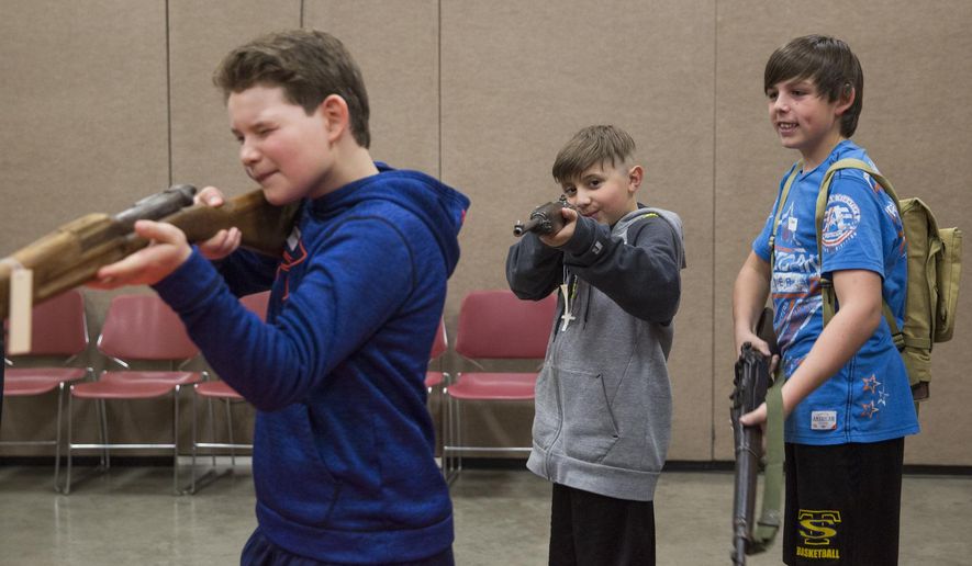 In a March 29, 2017 photo, Six-graders checked out the different guns that were carried by World War II soldiers as they attended World War II Day on March 29, 2017 at the Cam-plex Energy Hall in Gillette, Wyo. Close to 800 sixth-graders packed Cam-plex Energy Hall for the Campbell County Rockpile Museum's World War II Day, an annual event where students see, hear, taste and feel what life was like in the early 1940s on the home front as well as on the front lines. (Kelly Wenzel/Gillette News Record via AP)