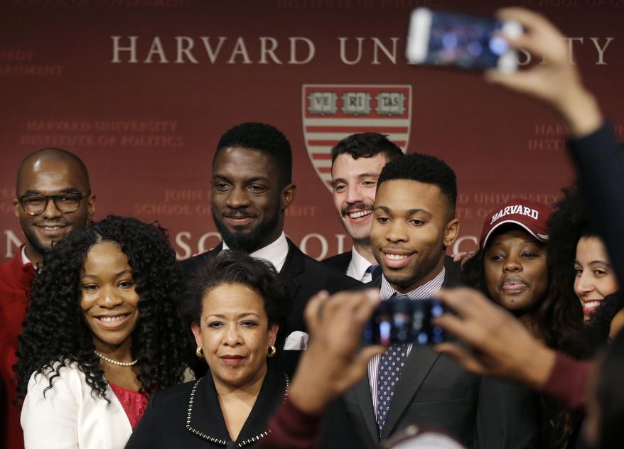 Former U.S. Attorney General Loretta Lynch, bottom center, the nation's first black woman to head the Justice Department, poses with students after speaking at a conference on policy and blacks at Harvard University's Kennedy School of Government, Friday, April 7, 2017, in Cambridge, Mass. The 57-year-old North Carolina native graduated from Harvard College in 1981 and from Harvard Law School in 1984. (AP Photo/Elise Amendola)