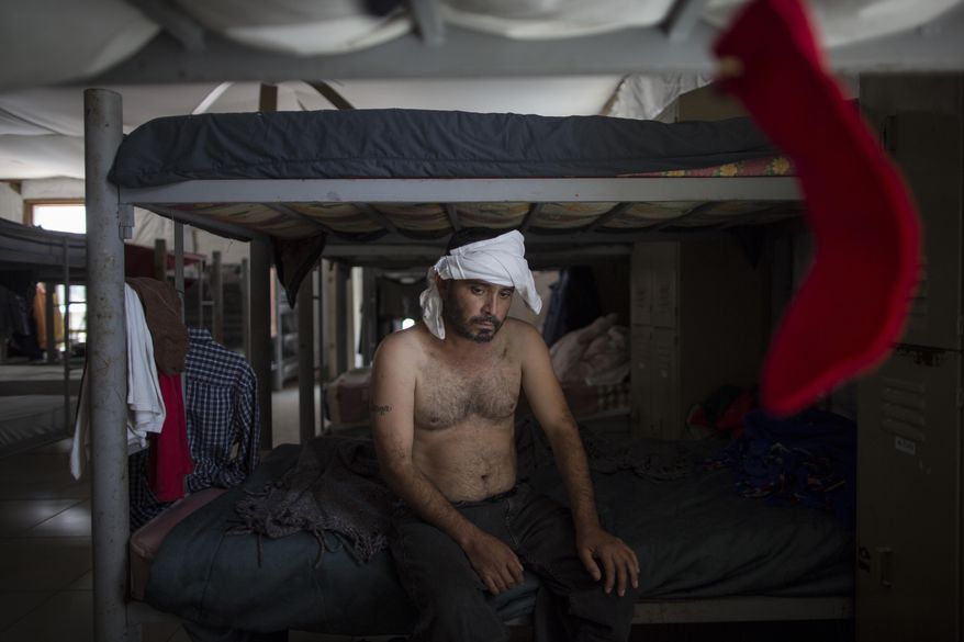 In this Wednesday, March 22, 2017 photo, Delfino Luis Trevino, with his head bandaged, rests on a bunk bed at the "Senda de Vida" migrant shelter in Reynosa, Mexico. Trevino, from Veracruz, Mexico, said he was beaten one week ago by "coyotes", slang for the guides who smuggle migrants across the border, because he tried to cross to McAllen, Texas, without hiring them. He said they where charging $500 dollars. (AP Photo/Rodrigo Abd)