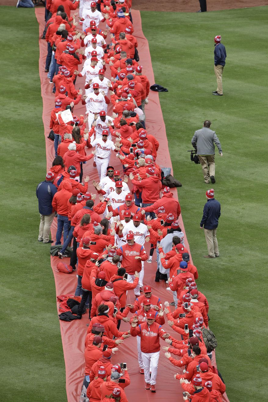 The Philadelphia Phillies walk onto the field ahead of a baseball game against the Washington Nationals in Philadelphia, Friday, April 7, 2017. (AP Photo/Matt Rourke)