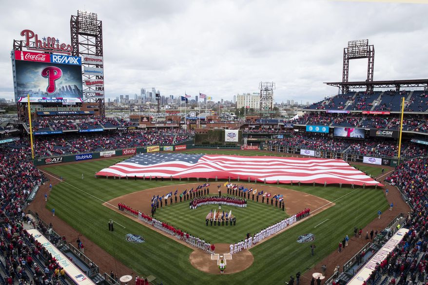 Members of the Philadelphia Phillies and the Washington Nationals stand for the national anthem ahead of their baseball game in Philadelphia, Friday, April 7, 2017. (AP Photo/Matt Rourke)