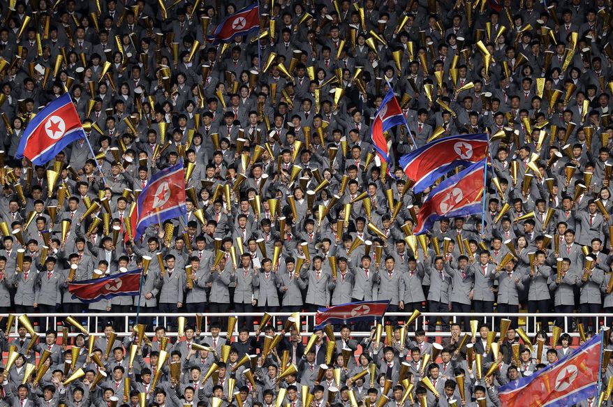 North Korean university students cheer and wave their national flag as their country's women's soccer team competes against South Korea in a qualifying soccer match for the Asian Football Confederation Cup at the Kim Il Sung Stadium on Friday, April 7, 2017, in Pyongyang, North Korea. (AP Photo/Jon Chol Jin)