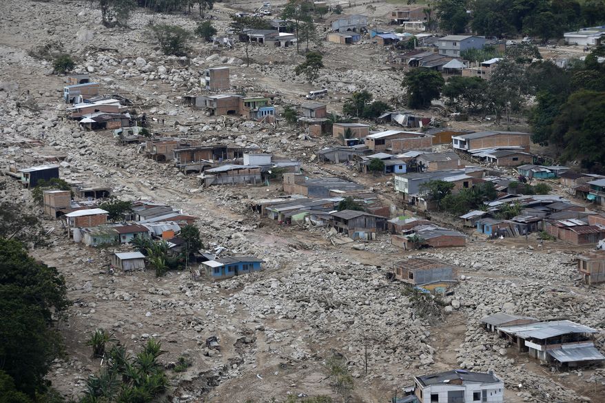 Boulders and debris surround homes on Tuesday, April 4, 2017, after rivers surrounding Mocoa, Colombia overflowed and sent a wall of water and debris surging through the city over the weekend. Authorities said hundreds were killed. (AP Photo/Fernando Vergara)