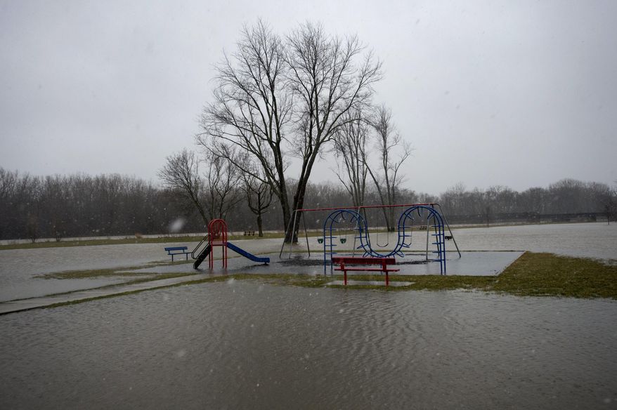 The Tittabawassee River floods West Michigan Park on West Michigan in Saginaw Township, Mich., on Thursday morning, April 6, 2019. Rain, snow, flooding and gusty winds are in the forecast for the Saginaw area all day into Friday. (Jeff Schrier/The Saginaw News via AP)