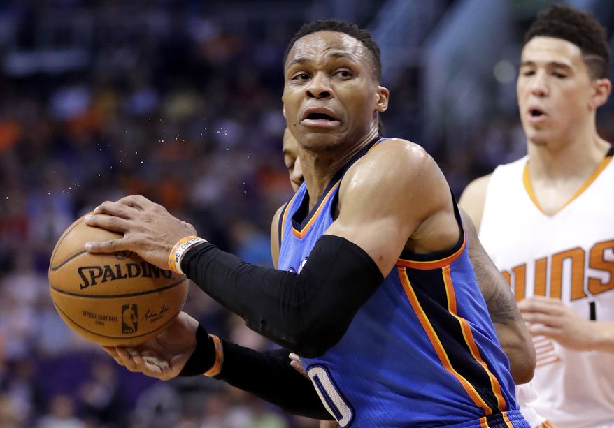 Oklahoma City Thunder guard Russell Westbrook (0) spins around Phoenix Suns guard Devin Booker during the first half of an NBA basketball game, Friday, April 7, 2017, in Phoenix. (AP Photo/Matt York)