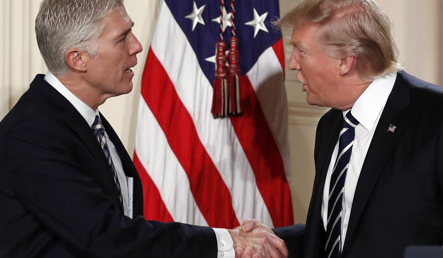 FILE - In this Jan. 31, 2017, file photo, President Donald Trump shakes hands with Judge Neil Gorsuch in East Room of the White House in Washington, as he announces Grouch as his nominee for the Supreme Court. With Gorsuch on the verge of confirmation to the Supreme Court, Trump is nearing his first major legislative achievement. It will be victory for the insiders. (AP Photo/Carolyn Kaster, File)
