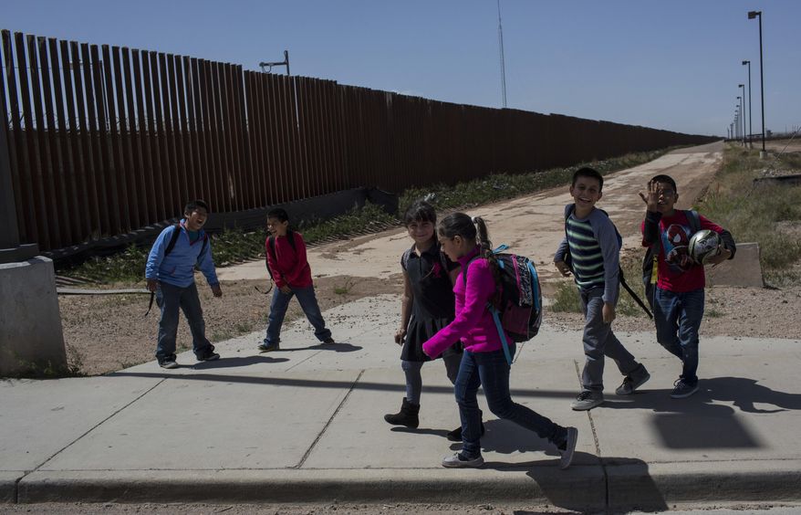In this Friday, March 31, 2017 photo, Columbus Elementary School students, cross the border from Columbus, New Mexico, US, into Palomas, Mexico, after a day of school. Every morning about 1,200 American kids in backpacks and sneakers arrive at the U.S. port of entry on the border with Puerto Palomas, Mexico, where they board yellow buses to be transported to nearby schools in Columbus and Deming, New Mexico. (AP Photo/Rodrigo Abd)