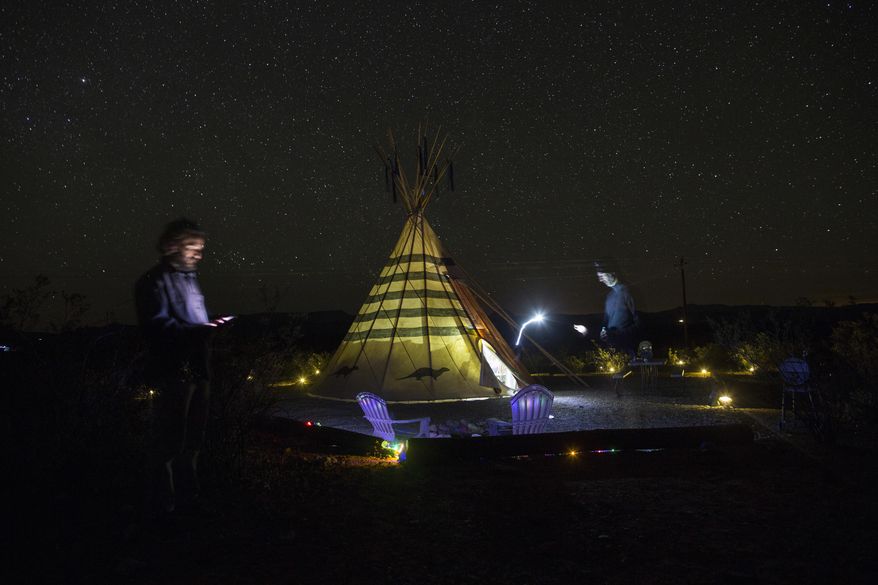 This Monday, March 27, 2017 photo show Associated Press team, photographer Rodrigo Abd, left, and writer Christopher Sherman, outside teepee hotel lodging at the Tin Valley Reto rentals in Terlingua, Texas, near the US-Mexico border. (AP Photo/Rodrigo Abd)