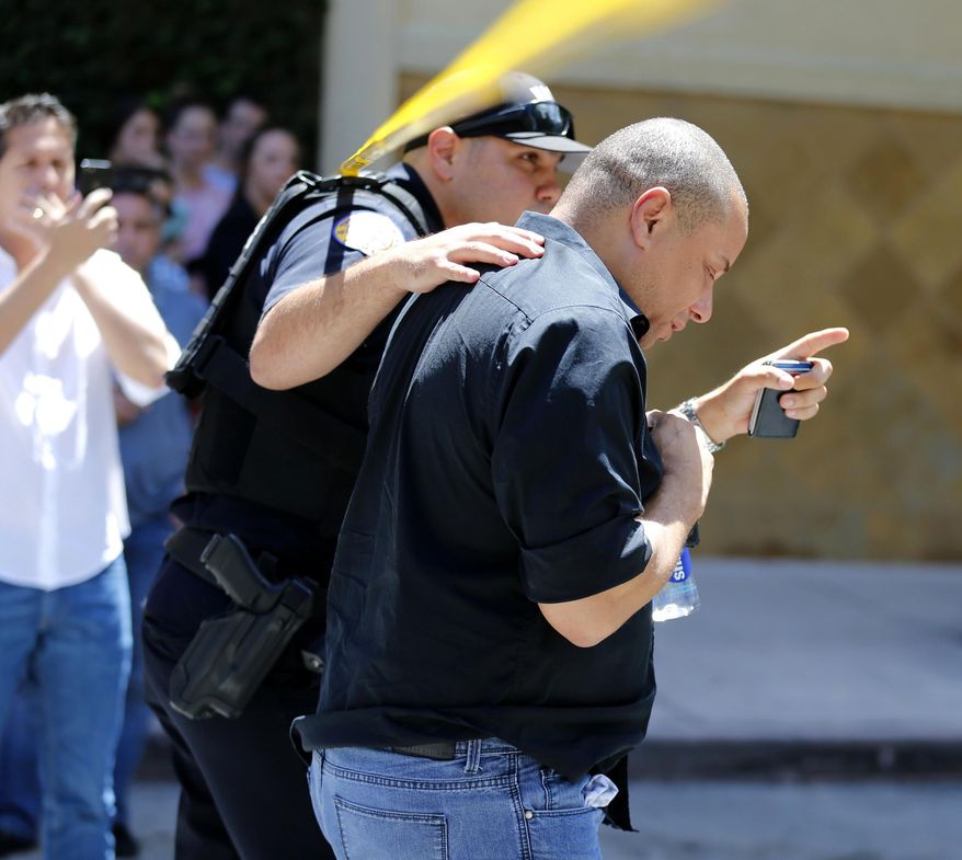 A man is evacuated from the scene after a gunman opened fire at the Shops at Merrick Park in Coral Gables, Fla., on Saturday, April 8, 2017. (Al Diaz/Miami Herald via AP)