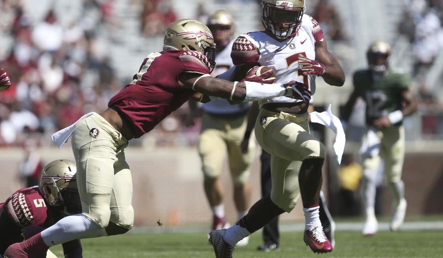 Florida State's Cam Akers tries to break away from Stanford Samuels III during the NCAA college football team's Garnet and Gold spring game in Tallahassee, Fla., Saturday, April 8, 2017. (Joe Rondone/Tallahassee Democrat via AP)