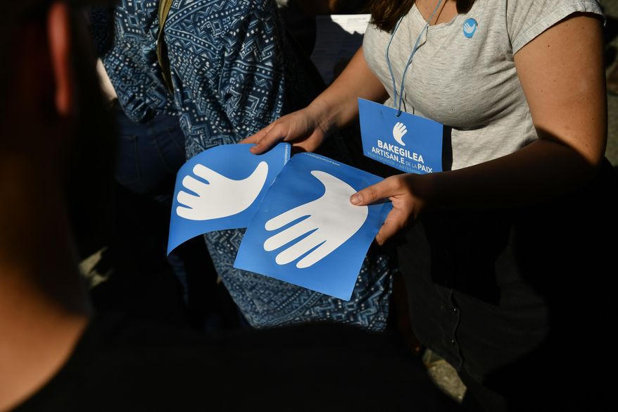 A pro independence Basque follower offers the symbol of the day called ''Artisans of the Peace'', during a meeting after the announcement that ETA handed over its arms in Bayonne, southwestern France, Saturday, April 8, 2017. The Basque separatist group ETA, inactive for more than five years, handed over its arms Saturday, putting a finishing touch to a 43-year violent campaign that claimed the lives of over 800 people mostly in Spain. (AP Photo/Alvaro Barrientos)