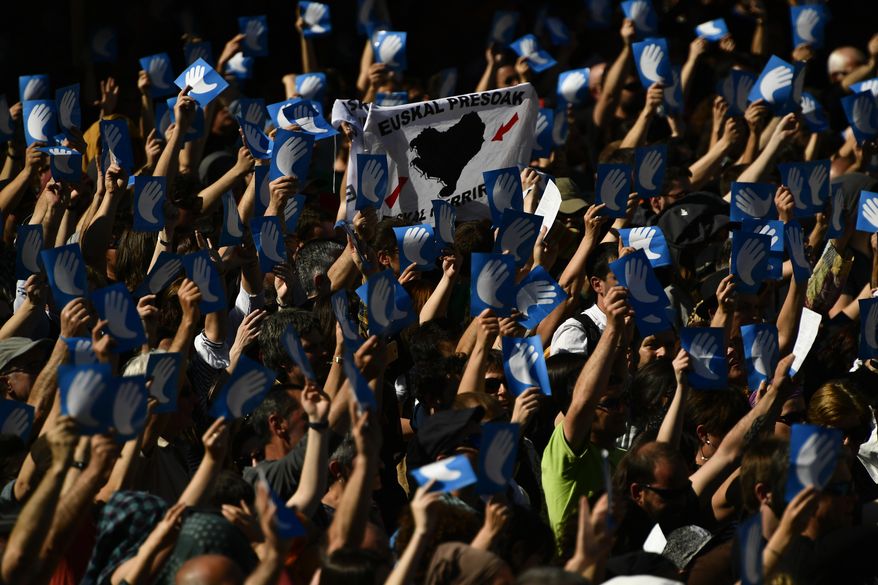 Pro independence Basque followers hold up the symbol of the day called ''Artisans of the Peace'', during a meeting after the announcement that ETA handed over its arms in Bayonne, southwestern France, Saturday, April 8, 2017. The Basque separatist group ETA, inactive for more than five years, handed over its arms Saturday, putting a finishing touch to a 43-year violent campaign that claimed the lives of over 800 people mostly in Spain. (AP Photo/Alvaro Barrientos)