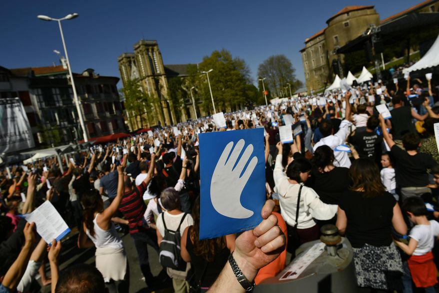 Pro independence Basque followers hold up the symbol of the day called ''Artisans of the Peace'', during a meeting after the announcement that ETA handed over its arms in Bayonne, southwestern France, Saturday, April 8, 2017. The Basque separatist group ETA, inactive for more than five years, handed over its arms Saturday, putting a finishing touch to a 43-year violent campaign that claimed the lives of over 800 people mostly in Spain. (AP Photo/Alvaro Barrientos)