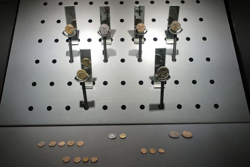 Ancient Roman copper, bronze and silver coins dated from the third century D.C. are on display in the San Giovanni underground station of Rome's brand new third metro line, Thursday, April 6, 2017. The metro station, set to open early next year, will double up as museum, boasting a display of archaeological remains brought to the surface during the new line's excavation, that passengers will admire as they head to their trains. (AP Photo/Andrew Medichini)
