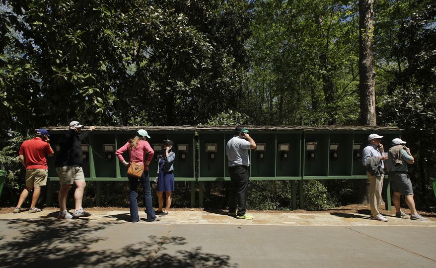 Patrons use pay phones on the Augusta National golf course during the third round of the Masters golf tournament Saturday, April 8, 2017, in Augusta, Ga. No cell phones are allowed on the course. (AP Photo/Charlie Riedel)