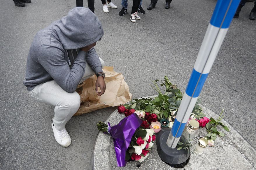 A man reacts in front of the offered flowers near the department store Ahlens following a suspected terror attack in central Stockholm, Sweden, Saturday, April 8, 2017. A Swedish prosecutor says a person has been formally identified as a suspect "of terrorist offenses by murder" by driving a hijacked truck into a crowd of pedestrians. (AP Photo/Markus Schreiber)