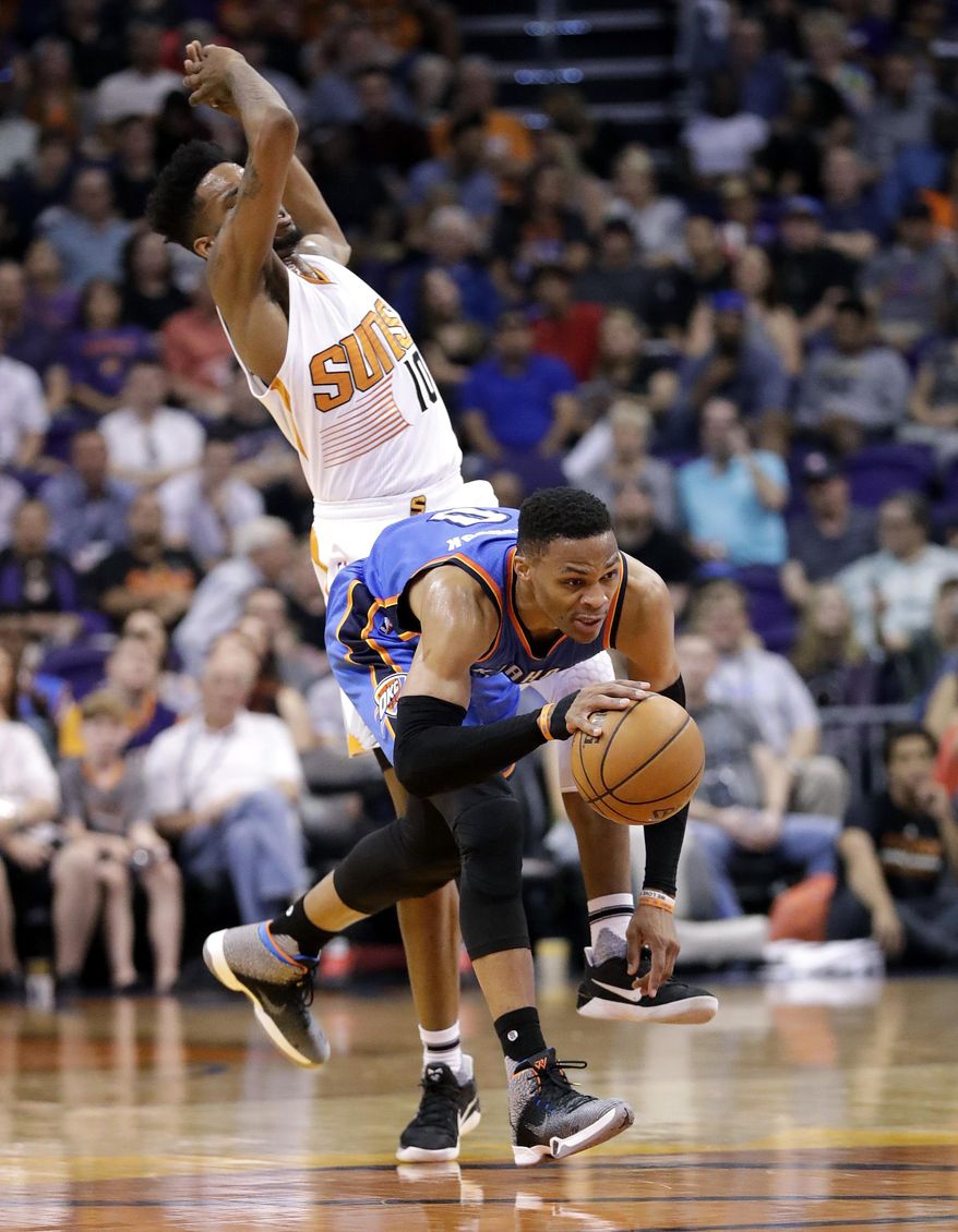 Phoenix Suns forward Derrick Jones Jr. (10) avoids a foul with Oklahoma City Thunder guard Russell Westbrook during the first half of an NBA basketball game, Friday, April 7, 2017, in Phoenix. (AP Photo/Matt York)