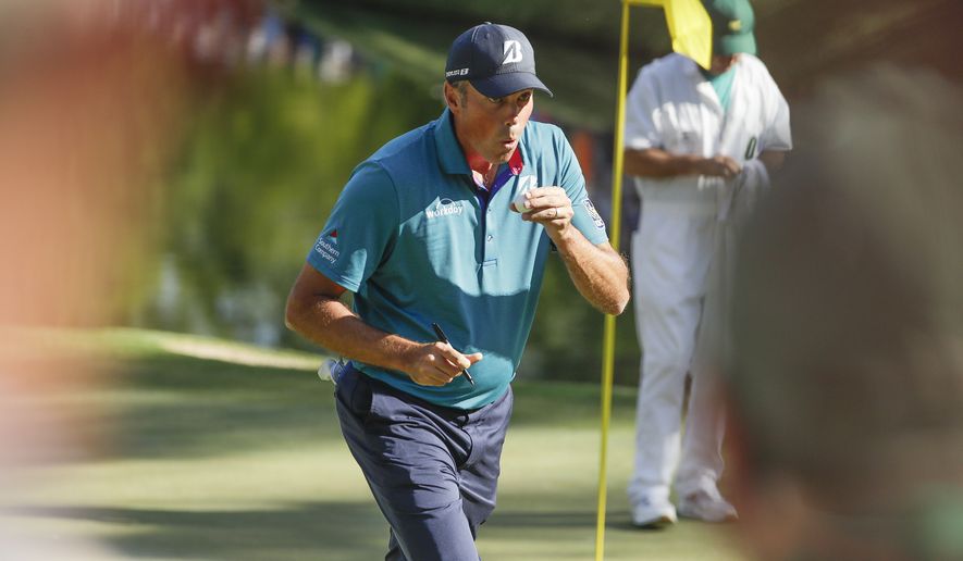 Matt Kuchar blows on his ball after hitting a hole in one on the 16th hole during the final round of the Masters golf tournament Sunday, April 9, 2017, in Augusta, Ga. (AP Photo/Matt Slocum)