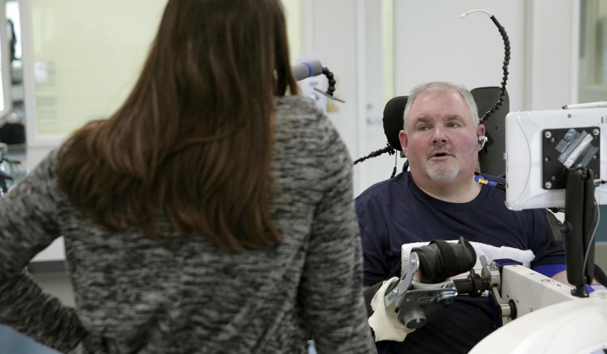 ADVANCE FOR SUNDAY, APRIL 9, 2017 - In this March 2017 photo Jeff Wirth, rights, talks with occupational therapist Erin McNamara at QLI Tri-Dimensional Rehab in Omaha, Neb. Wirth has been at QLI since June after suffering a spinal cord injury in February 2016 that left him a quadriplegic. ( Jeff Damron /The Daily Hub via AP)
