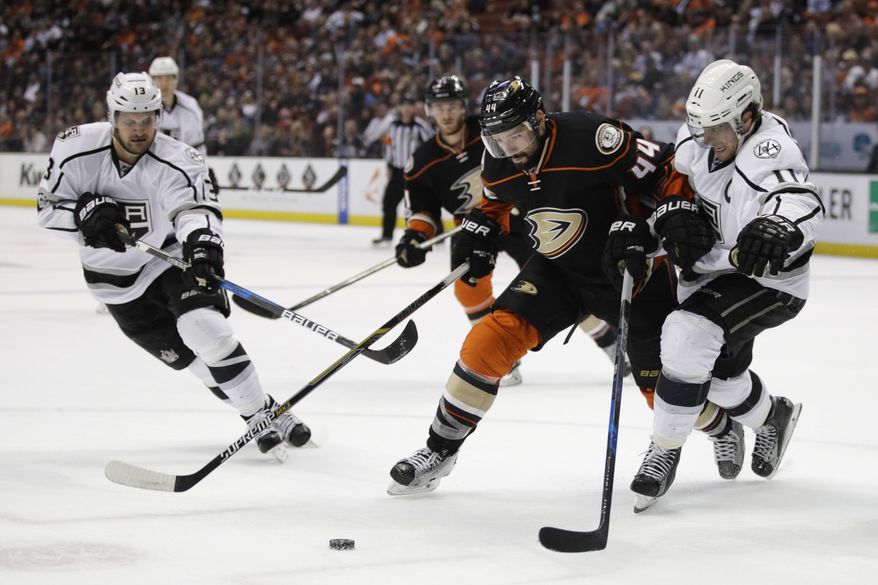 Los Angeles Kings&#x27; Anze Kopitar, right, of Slovenia, and Anaheim Ducks&#x27; Nate Thompson chase the puck during the first period of an NHL hockey game, Sunday, April 9, 2017, in Anaheim, Calif. (AP Photo/Jae C. Hong)