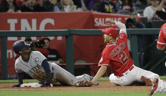 Los Angeles Angels&#39; Andrelton Simmons, right, looks at third base umpire Greg Gibson after applying a tag on Seattle Mariners&#39; Jean Segura during the third inning of a baseball game Saturday, April 8, 2017, in Anaheim, Calif. Segura was called out after a video review. (AP Photo/Jae C. Hong)