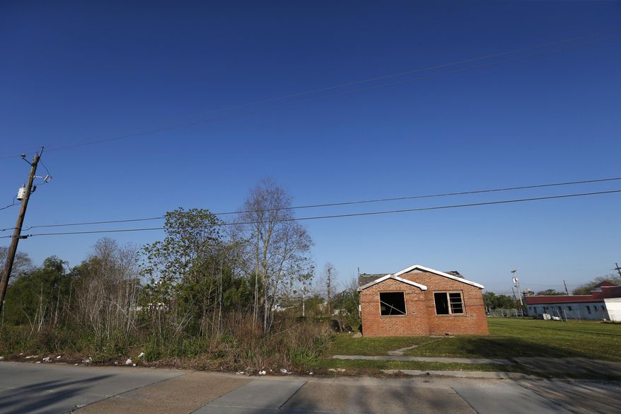 In this Thursday, March 16, 2017 photo, a blighted home and an empty, overgrown lot are seen in the Lower 9th Ward in New Orleans. The neighborhood of low-to-moderate-income residents was hit hard by Katrina and has struggled to recover. More than a decade after the hurricane, it still hasn’t recovered 50 percent of its population. (AP Photo/Gerald Herbert)