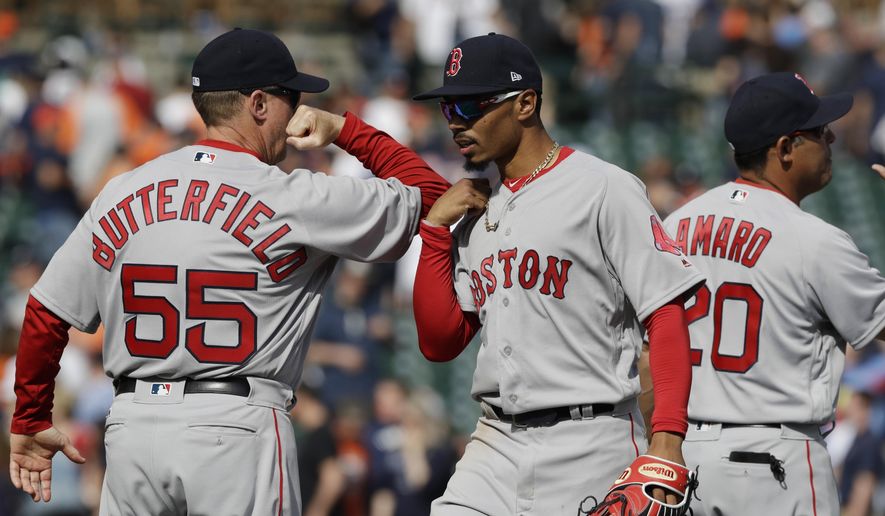 Boston Red Sox third base coach Brian Butterfield greets outfielder Mookie Betts after the team's 7-5 win over the Detroit Tigers in a baseball game, Sunday, April 9, 2017, in Detroit. (AP Photo/Carlos Osorio)