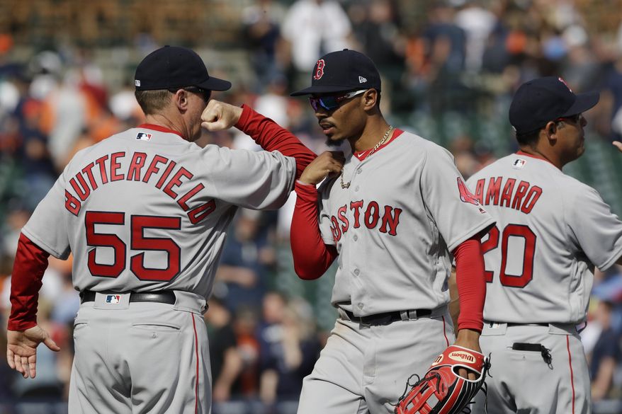 Boston Red Sox third base coach Brian Butterfield greets outfielder Mookie Betts after the team's 7-5 win over the Detroit Tigers in a baseball game, Sunday, April 9, 2017, in Detroit. (AP Photo/Carlos Osorio)
