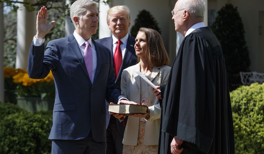 President Donald Trump watches as Supreme Court Justice Anthony Kennedy administers the judicial oath to Judge Neil Gorsuch during a re-enactment in the Rose Garden of the White House, Monday, April 10, 2017, in Washington. Gorsuch&#x27;s wife Marie Louise hold a bible at center. (AP Photo/Evan Vucci)