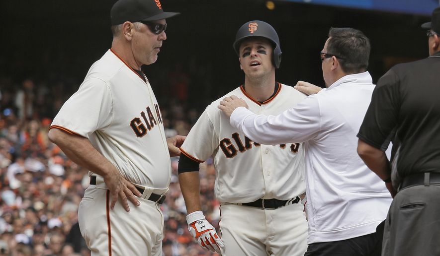 San Francisco Giants' Buster Posey, center, is checked by a trainer as manager Bruce Bochy, left, looks on after Posey was hit in the helmet by a fastball thrown by Arizona Diamondbacks starting pitcher Taijuan Walker in the first inning of a baseball game Monday, April 10, 2017, in San Francisco. Posey was forced out of the game. (AP Photo/Eric Risberg)