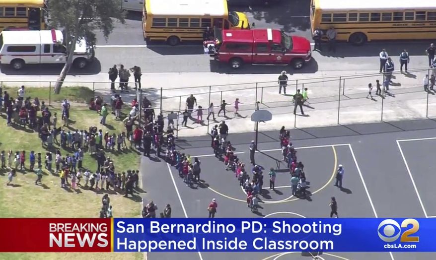 In this frame from video provided by KTTV Fox 11 and KCBS-TV, children are evacuated to school buses to be reunited with their parents at another location after a shooting inside North Park Elementary School in San Bernardino, Calif., Monday, April 10, 2017. (KTTV Fox 11/KCBS-TV via AP)