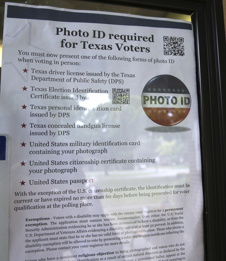 FILE - In this Nov. 5, 2013 file photo, a sign in a window tells of photo ID requirements for voting at a polling location in Richardson, Texas. A judge has ruled for a second time that Texas' strict voter ID law was intentionally crafted to discriminate against minorities.The ruling by U.S. District Judge Nelva Gonzales Ramos of Corpus Christi Monday, April 10, 2017, comes more than two years after she likened the ballot-box rules in Texas to a "poll tax" meant to suppress minority voters. (AP Photo/LM Otero, File)
