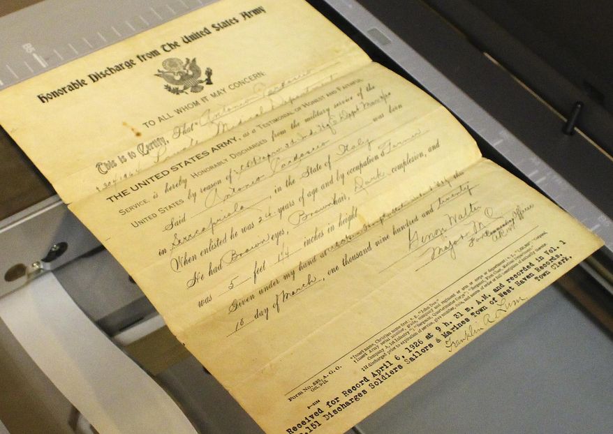 In this April 6, 2017 photo, a World War I discharge paper awaits scanning at the Connecticut State Library in Hartford, Conn. The library is in the midst of a project to digitally preserve photos, letters, documents and other artifacts from the war, which the U.S. entered 100 years ago this month. (AP Photo/Pat Eaton-Robb)
