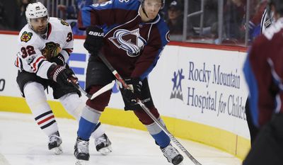 Colorado Avalanche center Mikhail Grigorenko, front, looks to pass the puck as Chicago Blackhawks defenseman Michal Rozsival, of the Czech Republic, covers in the third period overtime of an NHL hockey game Tuesday, April 4, 2017, in Denver. The Avalanche won 4-3 in overtime. (AP Photo/David Zalubowski)