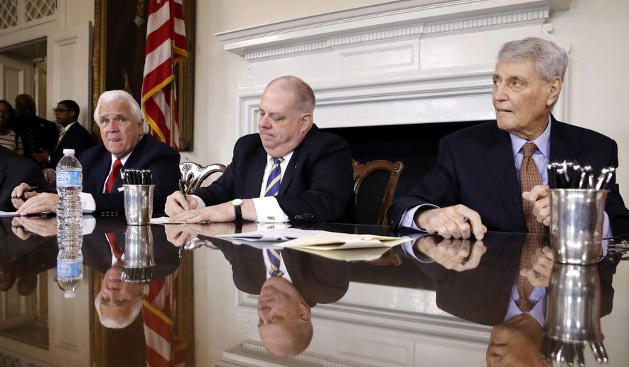 Maryland Gov. Larry Hogan, center, signs a bill between Senate President Thomas V. Mike Miller, left, and House Speaker Michael Busch during a bill signing ceremony following the state's legislative session at the Maryland State House in Annapolis, Md., Tuesday, April 11, 2017. (AP Photo/Patrick Semansky)
